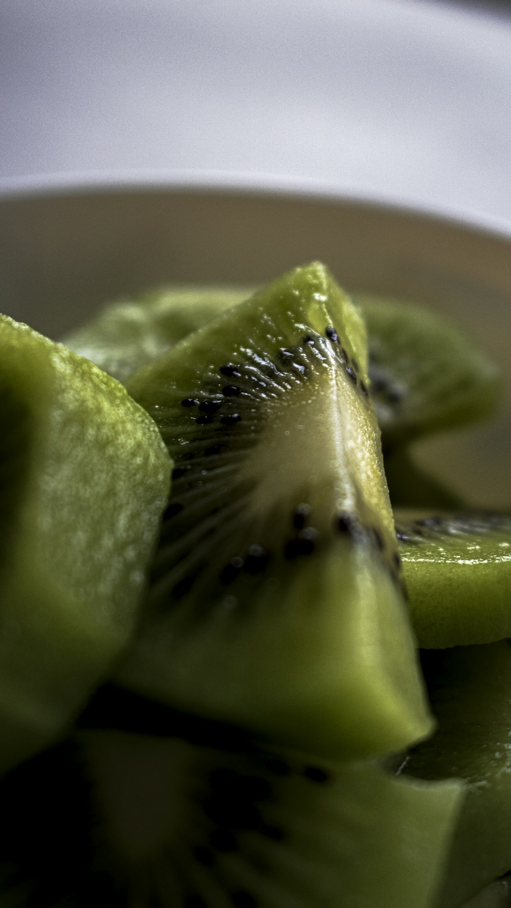 a white bowl filled with sliced kiwis on top of a table