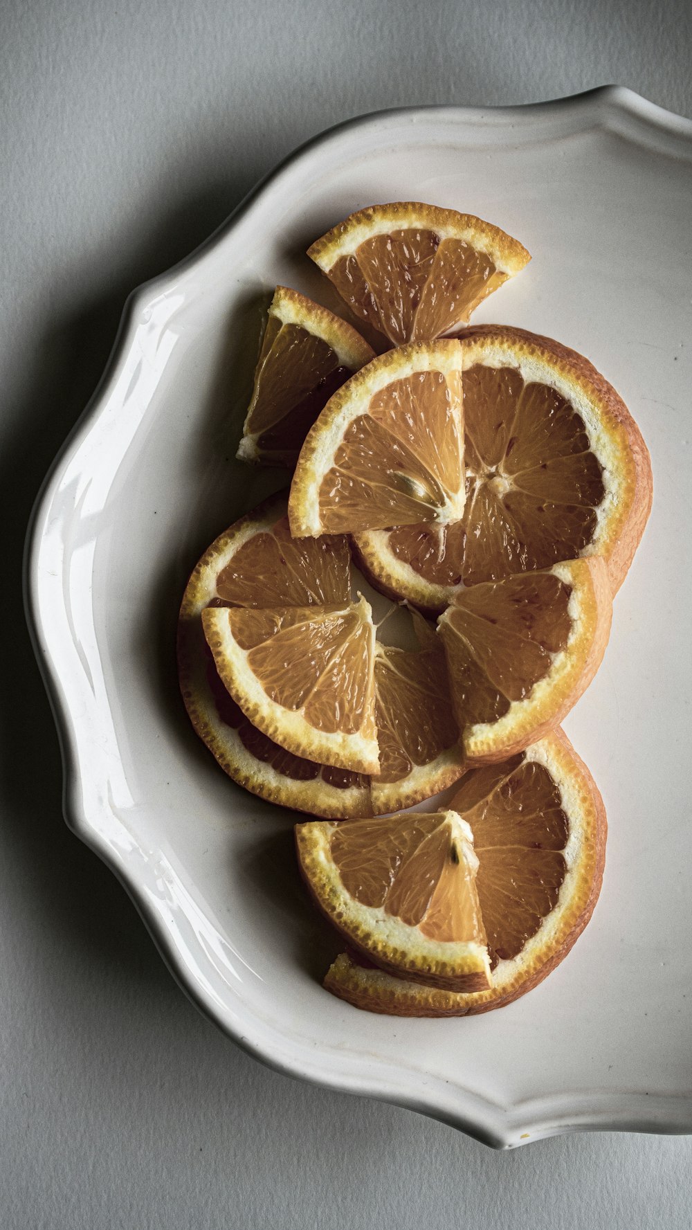 a white plate topped with sliced oranges on top of a table