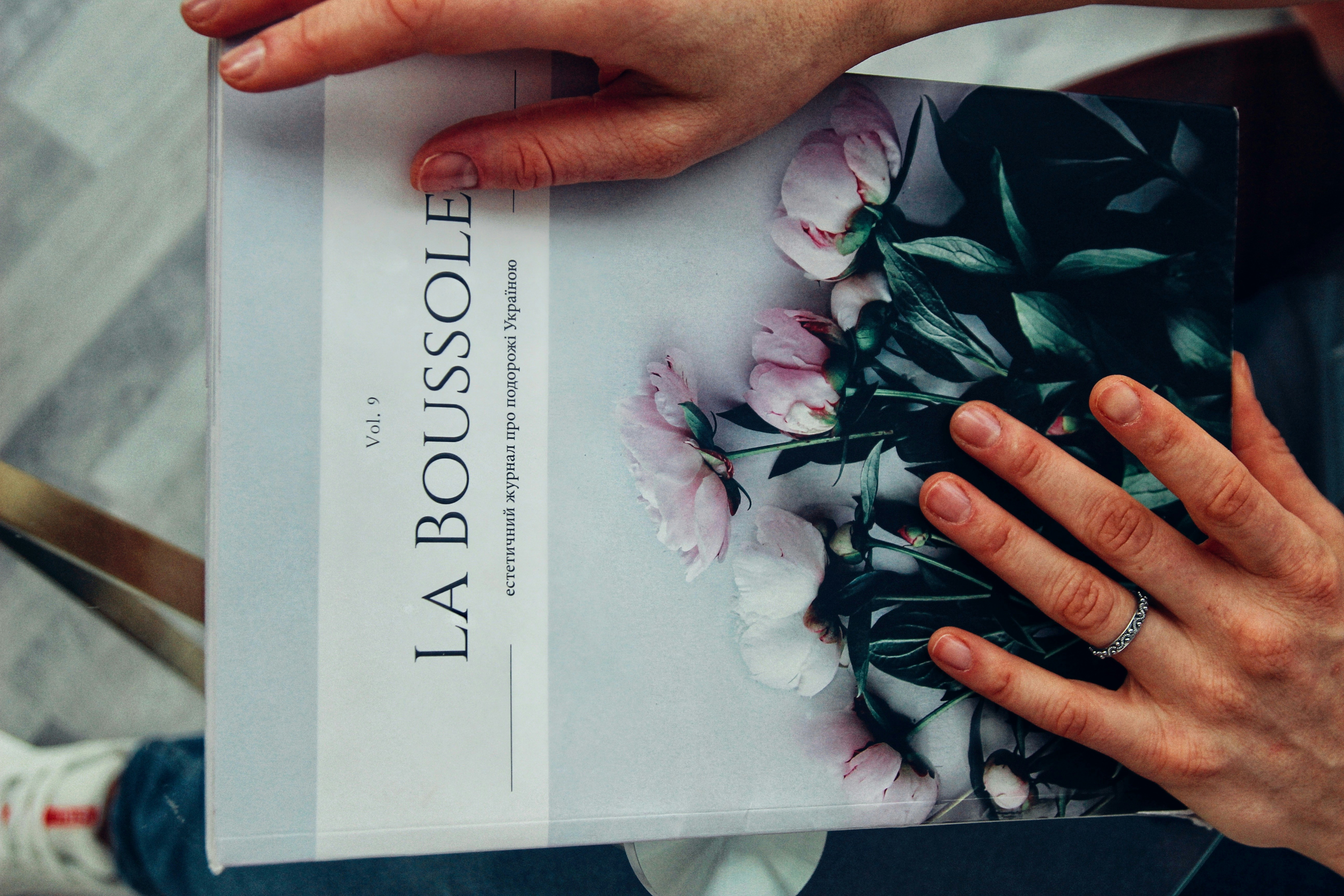 a person holding a book with flowers on it
