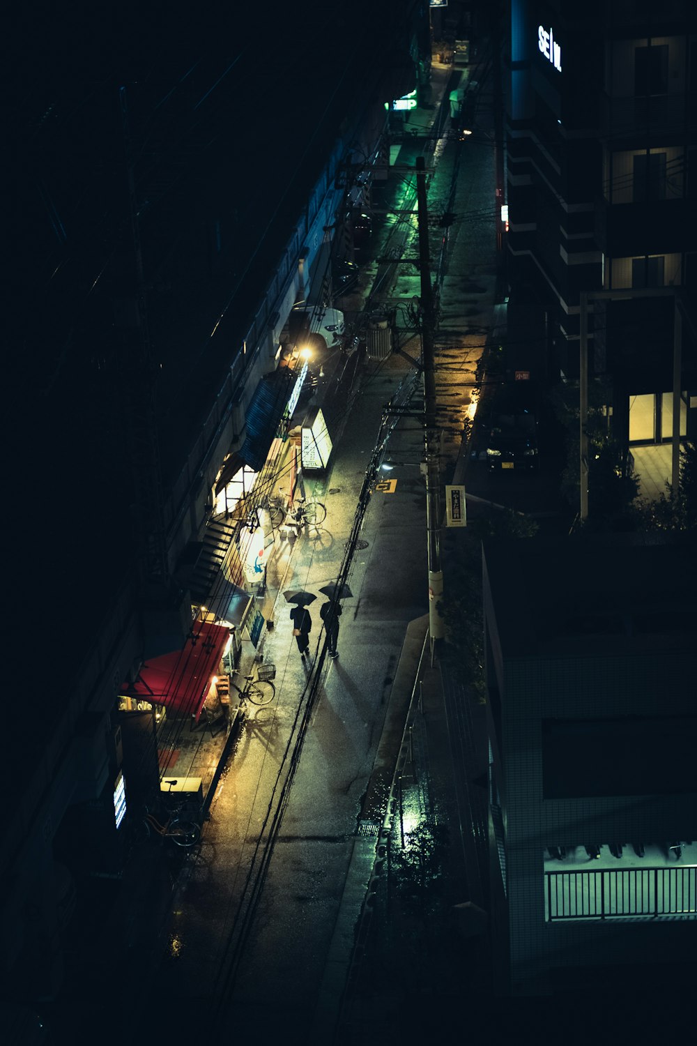 una calle de la ciudad por la noche con gente caminando por la acera
