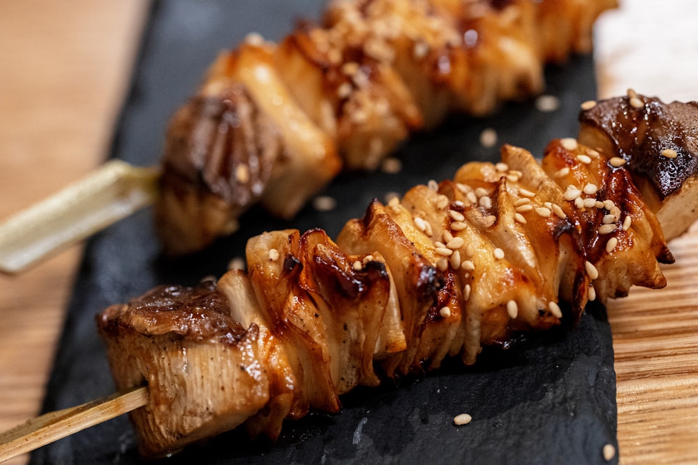 a close up of a skewer of food on a wooden table
