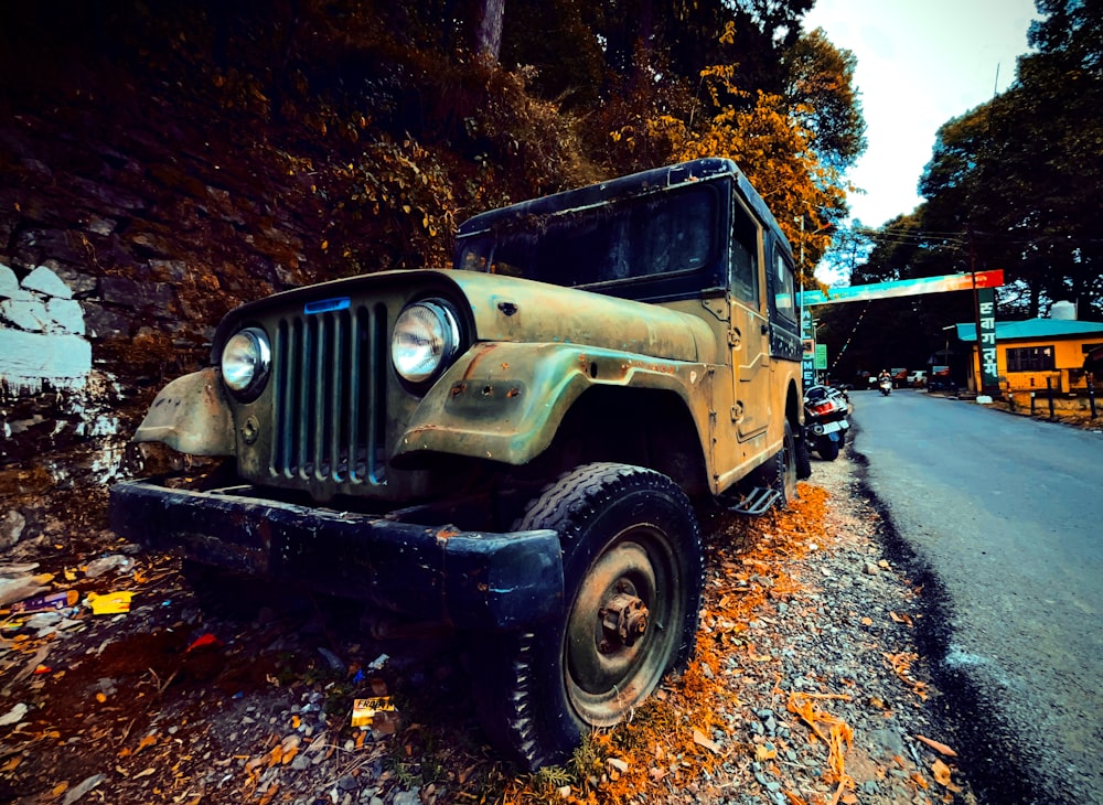 an old jeep is parked on the side of the road
