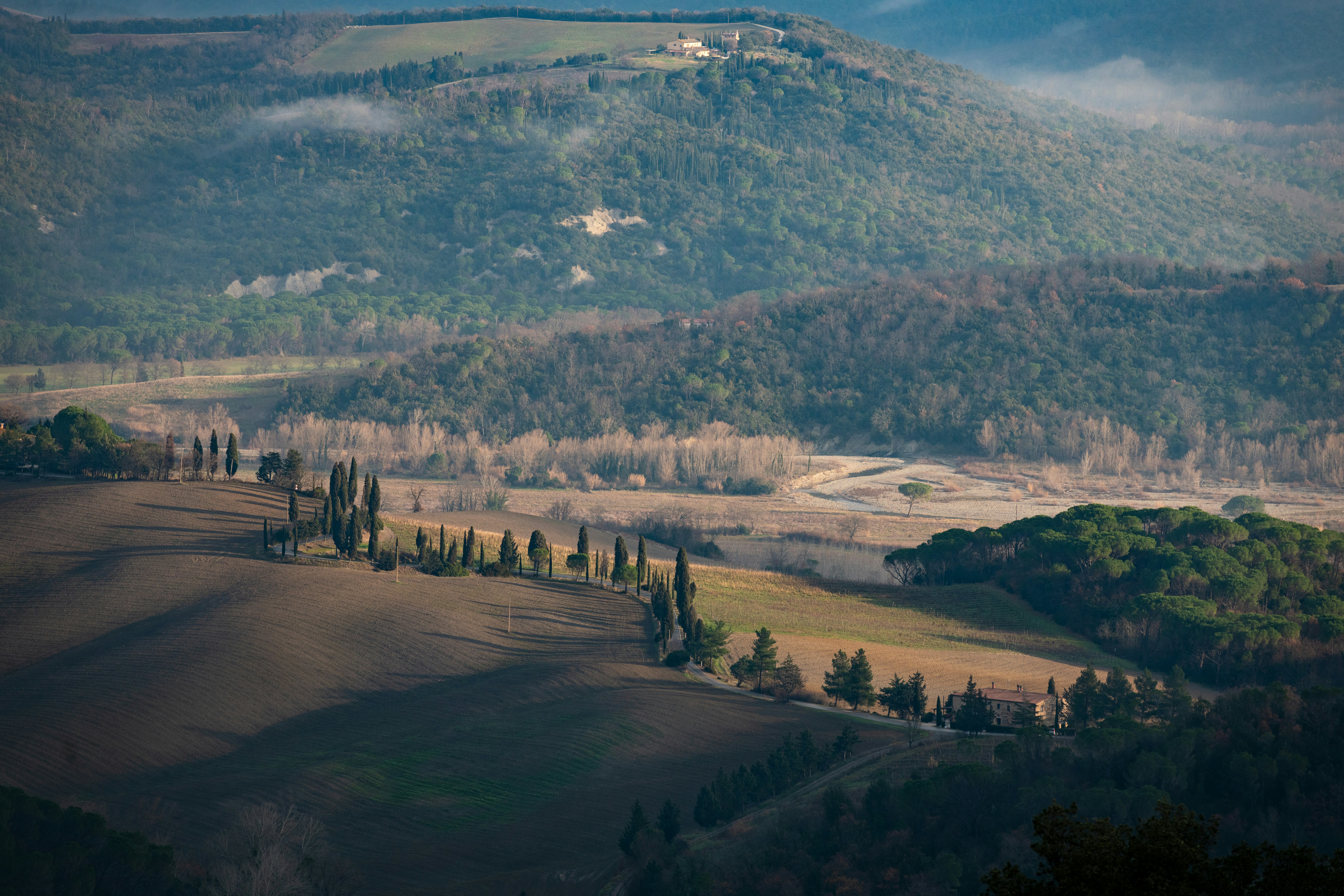 A scenic view of a valley with rolling hills in the background