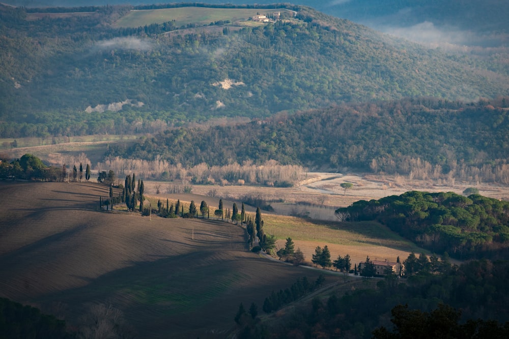 a scenic view of a valley with rolling hills in the background