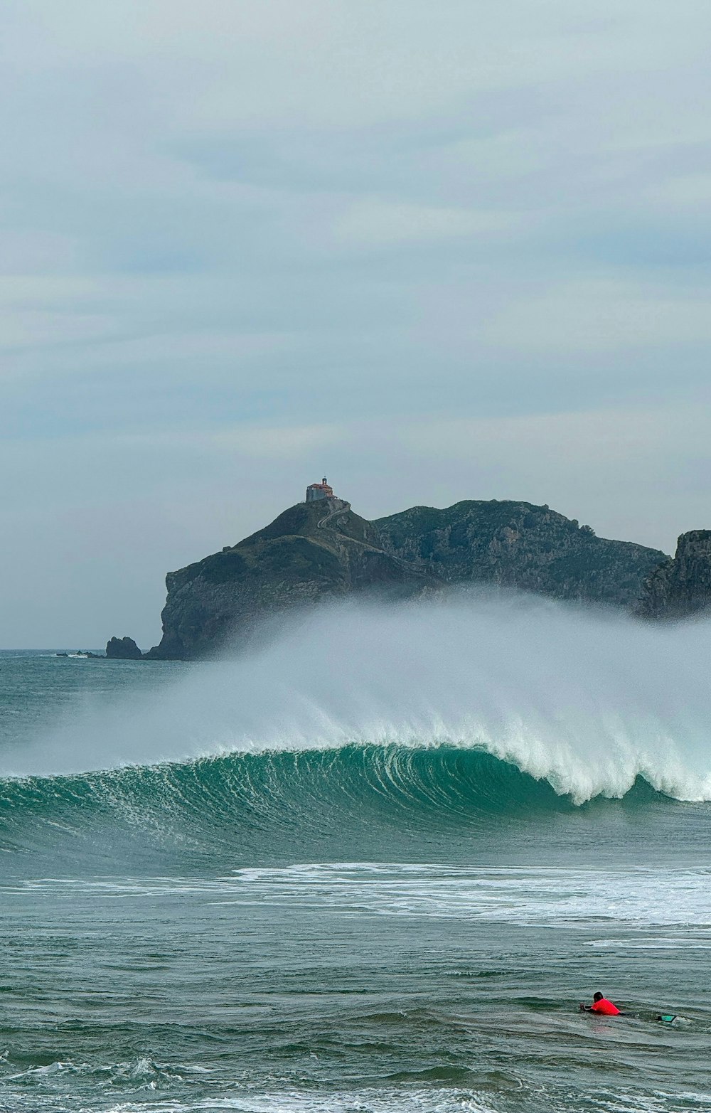 una persona montando una tabla de surf en una ola en el océano