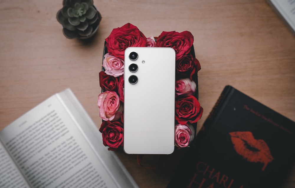 a cell phone sitting on top of a table next to a book