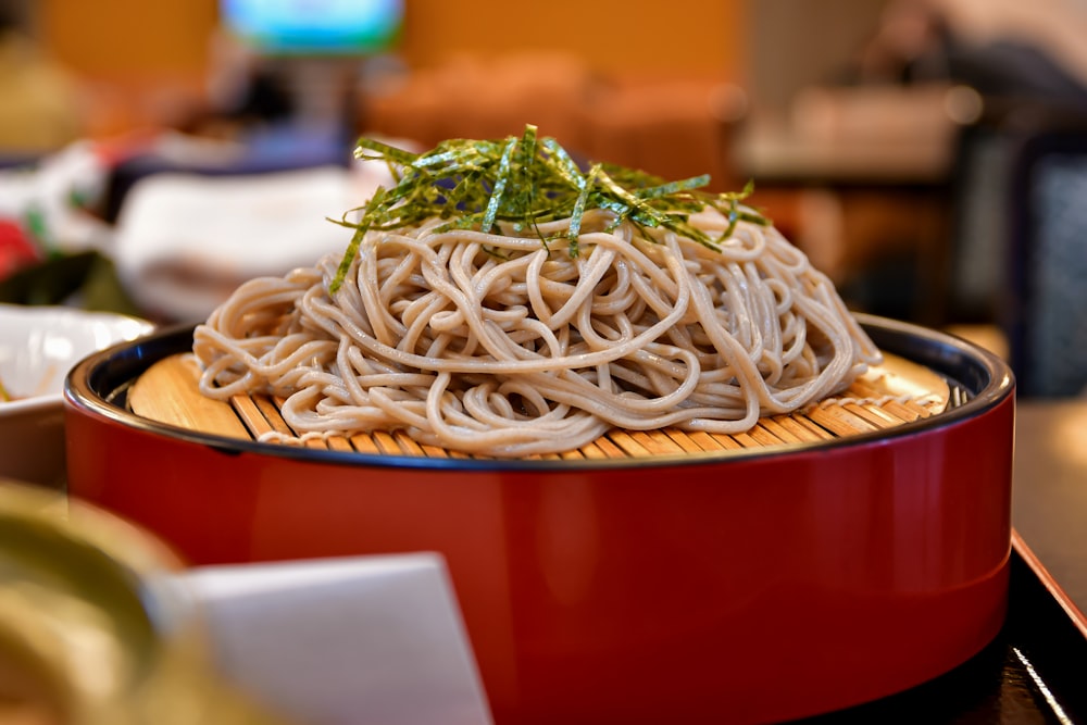 a plate of noodles with a green garnish on top