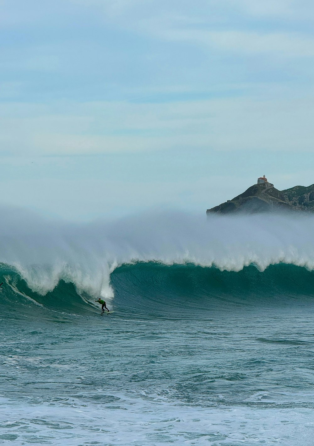 a man riding a wave on top of a surfboard