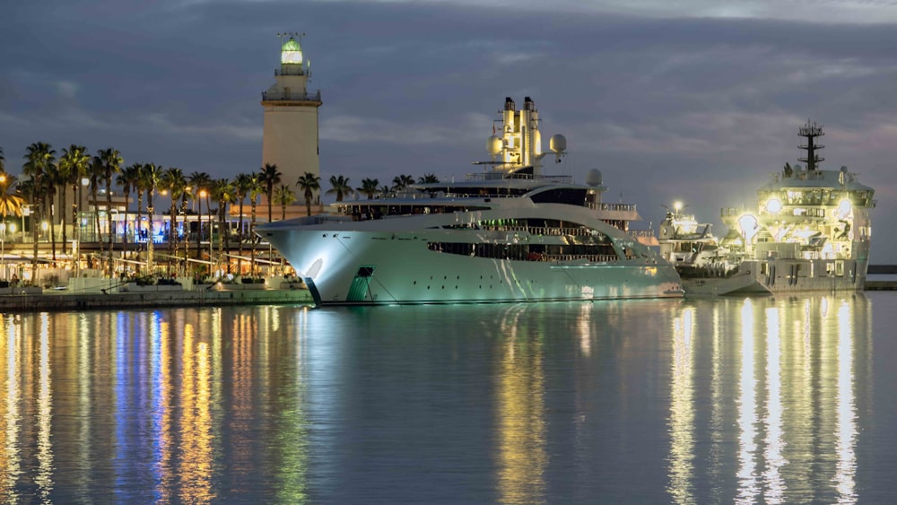 a cruise ship docked in a harbor at night