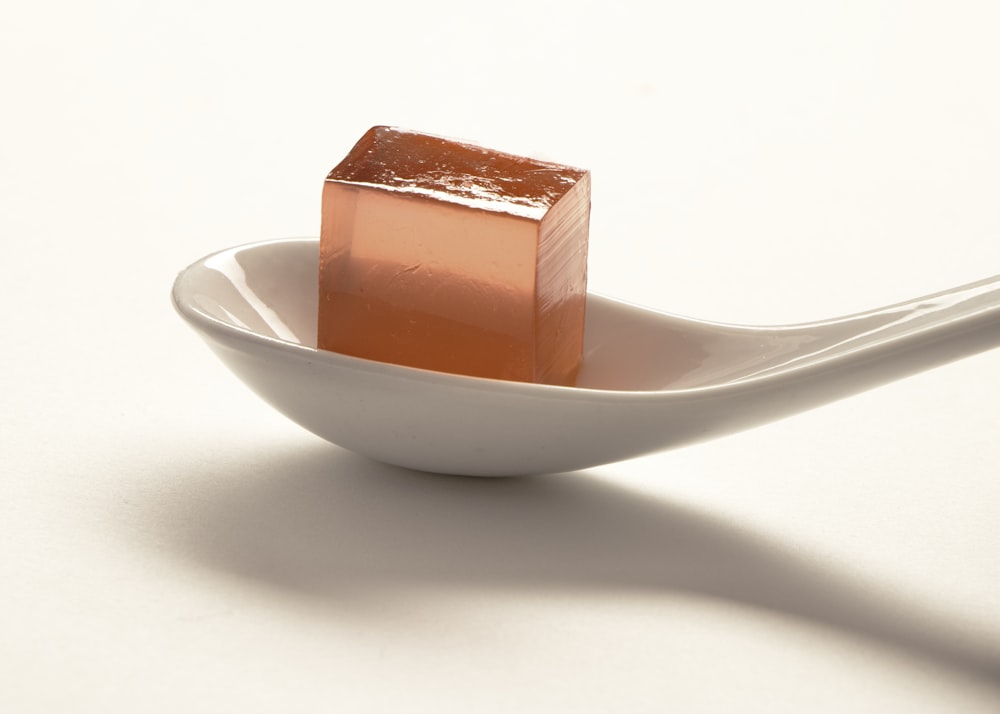 a spoon with a small cube of sugar on it