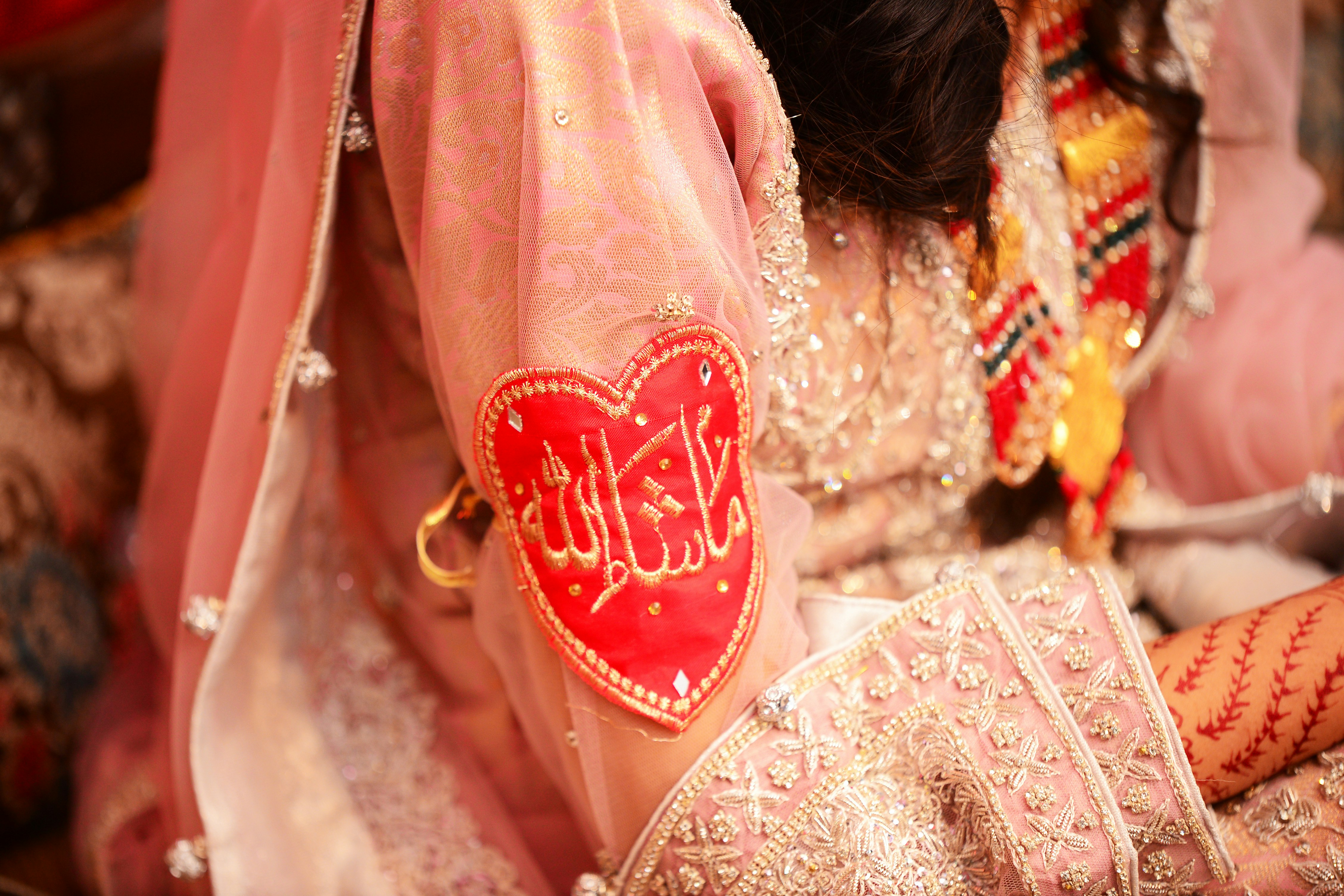 a close up of a bride's hand with a red heart on it