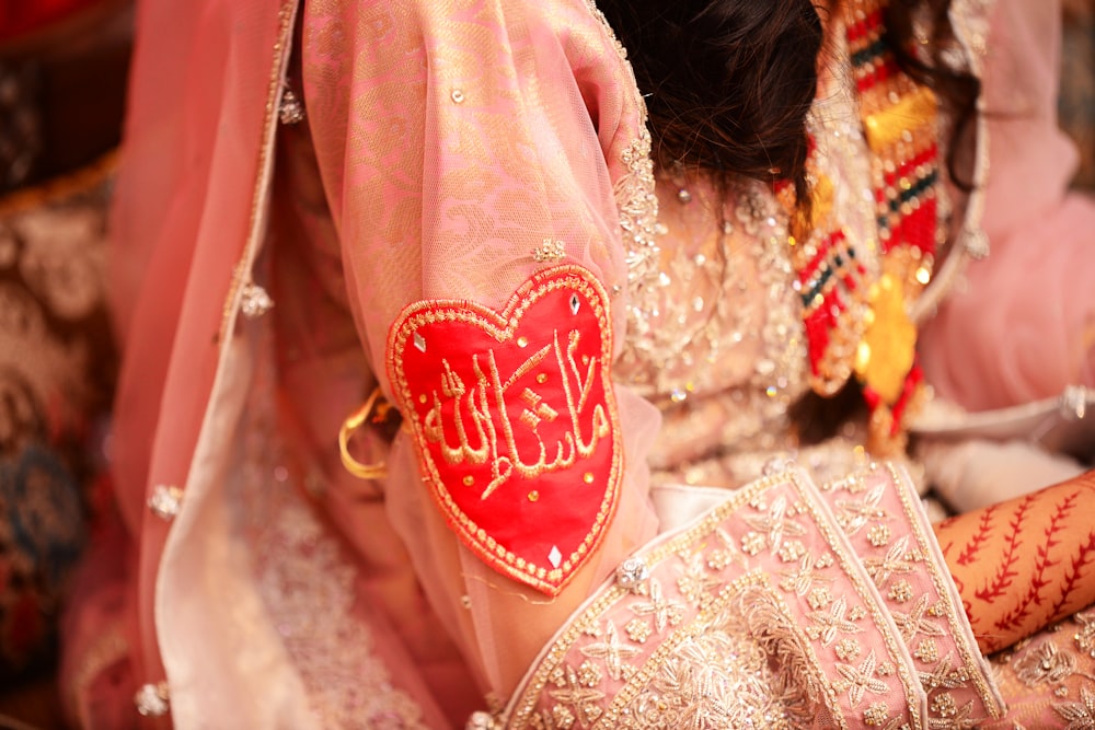 a close up of a bride's hand with a red heart on it