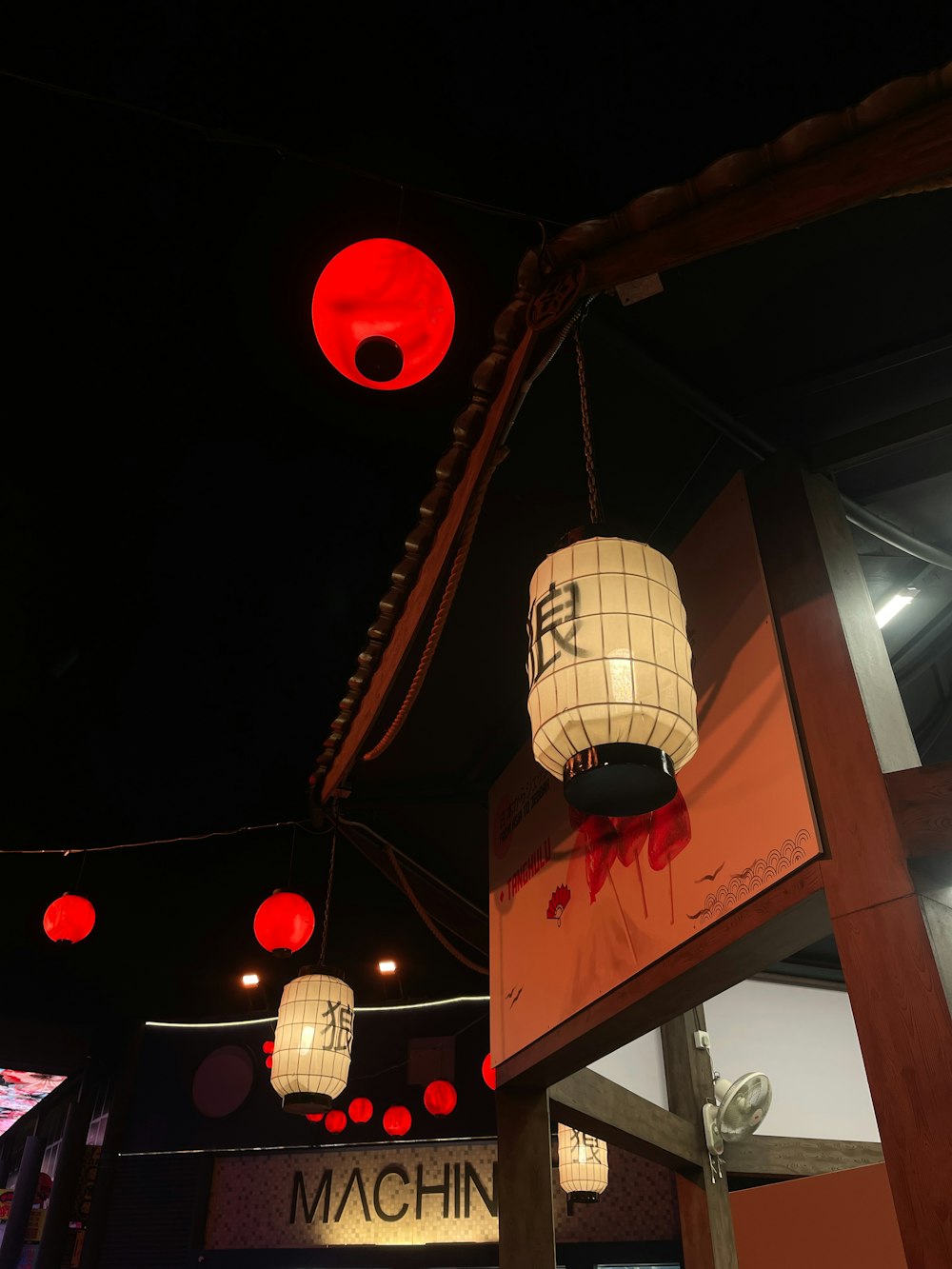 um restaurante com lanternas vermelhas penduradas no teto