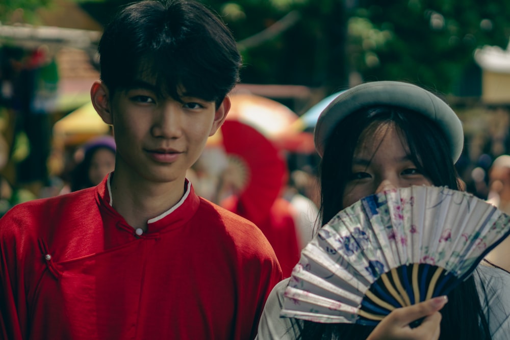 a boy and a girl are holding a fan
