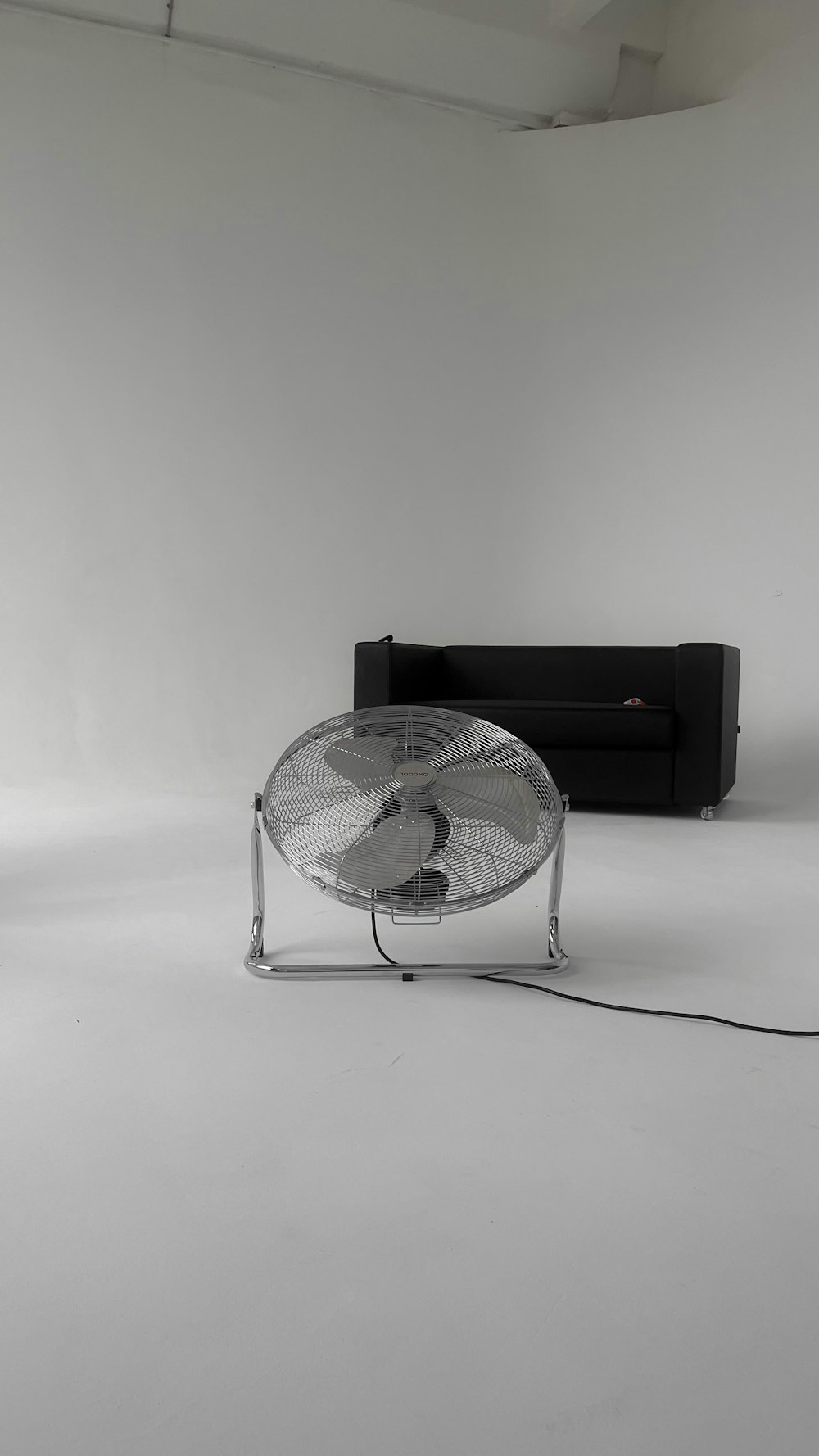 a black couch and a fan in a room