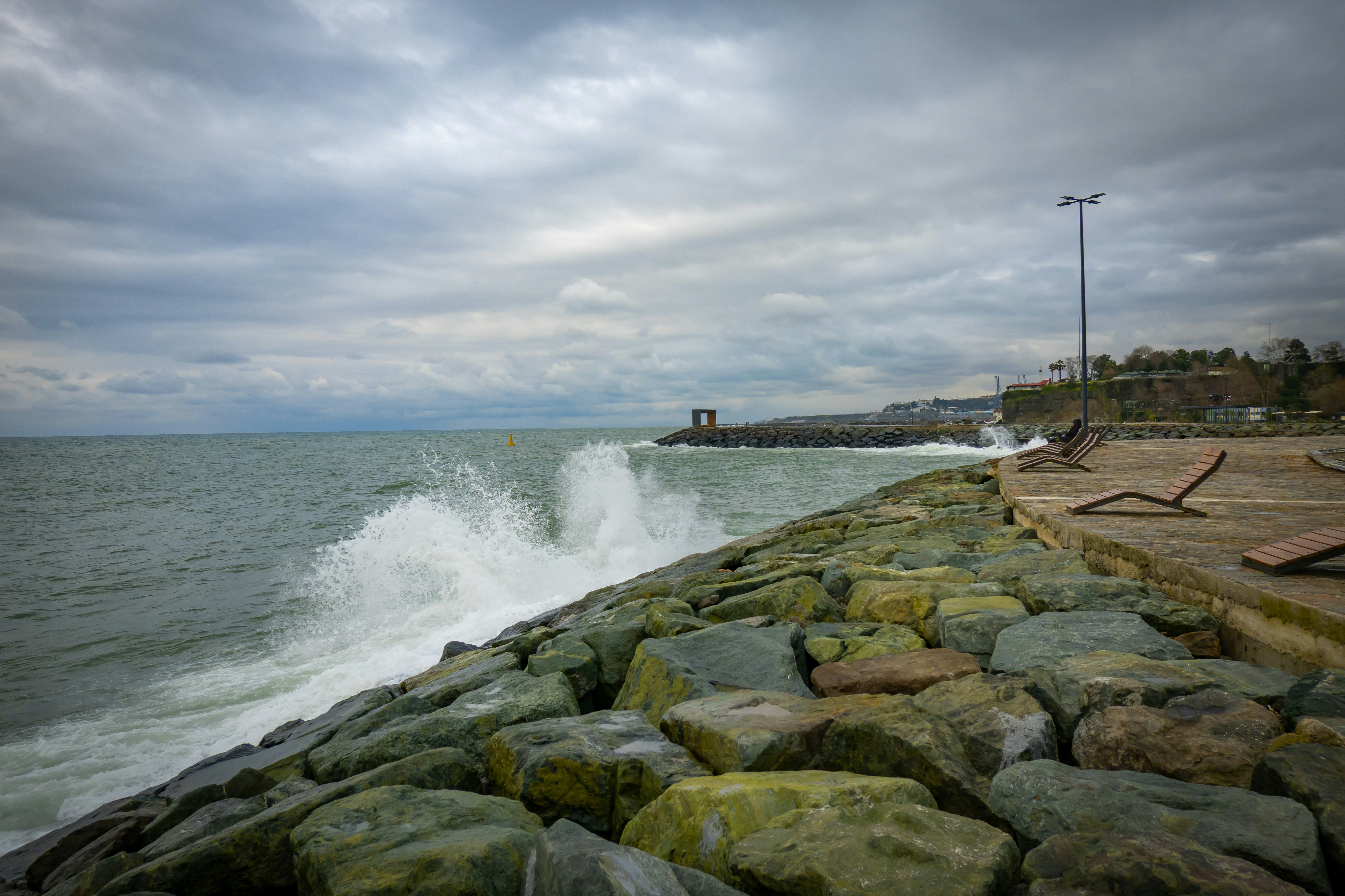 Une grande étendue d’eau assise à côté d’un rivage rocheux photo ...