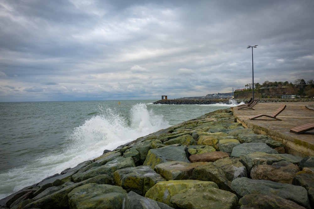 a large body of water sitting next to a rocky shore