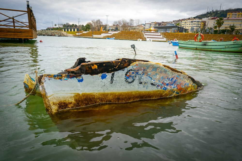 a rusted boat sitting in the middle of a body of water