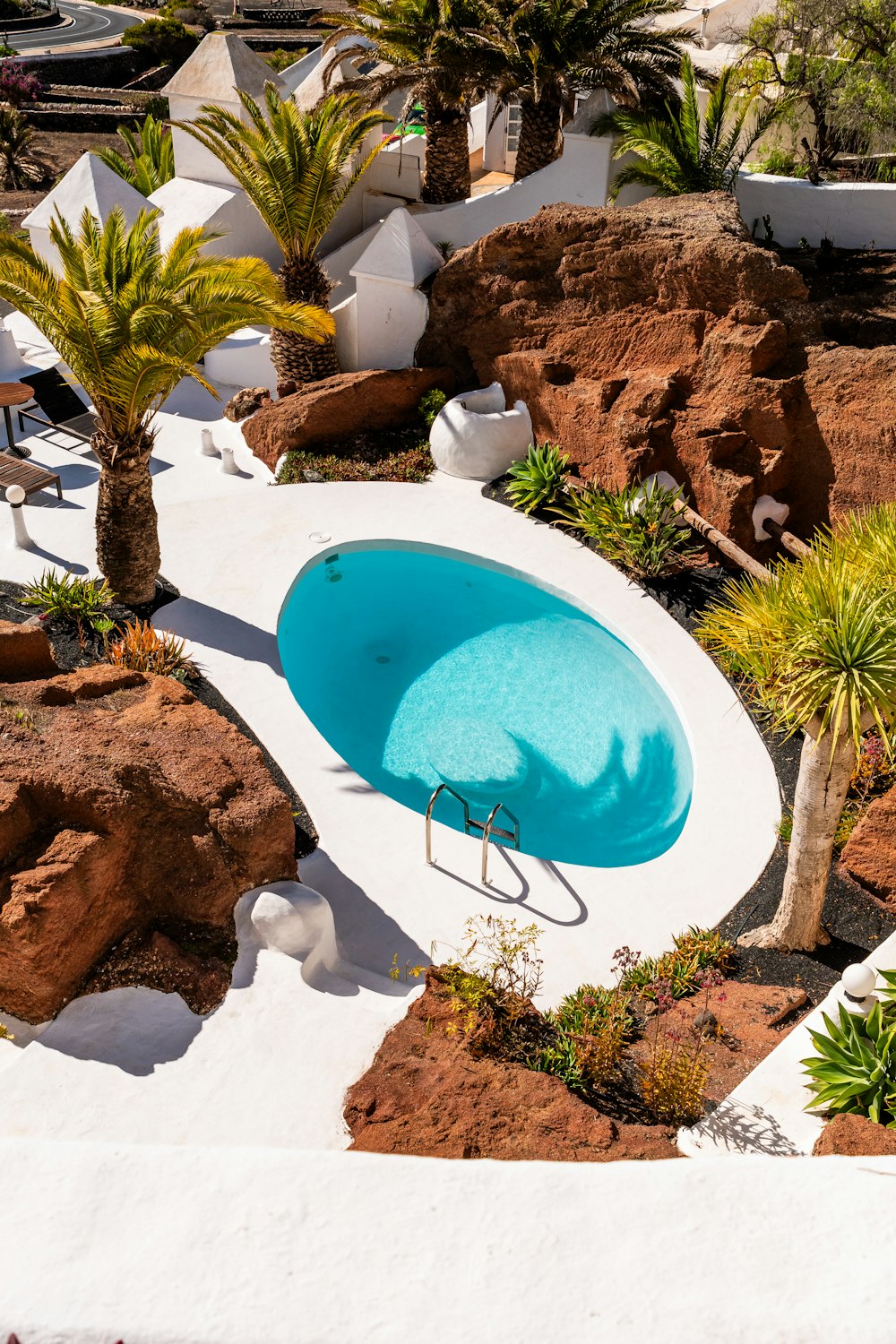 an aerial view of a pool surrounded by rocks