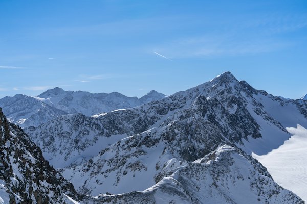 A mountain range covered in snow under a blue sky — Sölden, Austria