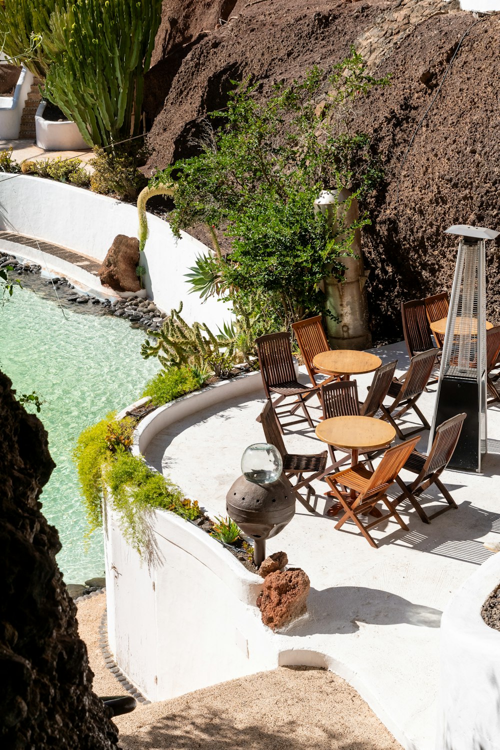 a patio with a table and chairs next to a pool