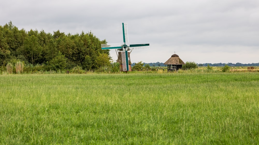 a green field with a windmill in the background