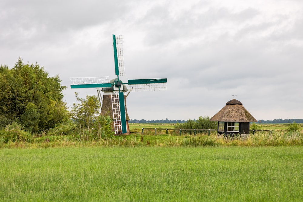 a windmill sitting in a field next to a house