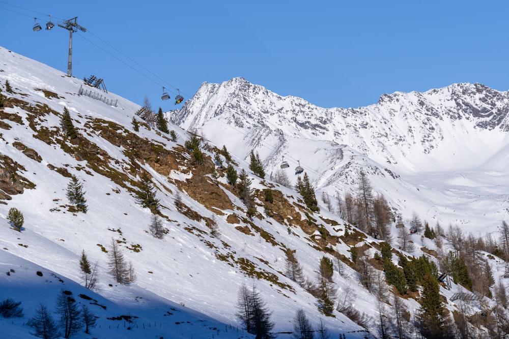 a ski lift going up the side of a snowy mountain