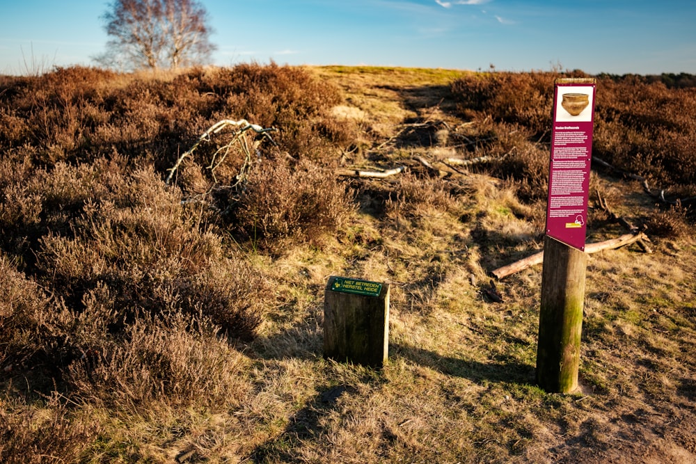 a sign on a wooden post in a field