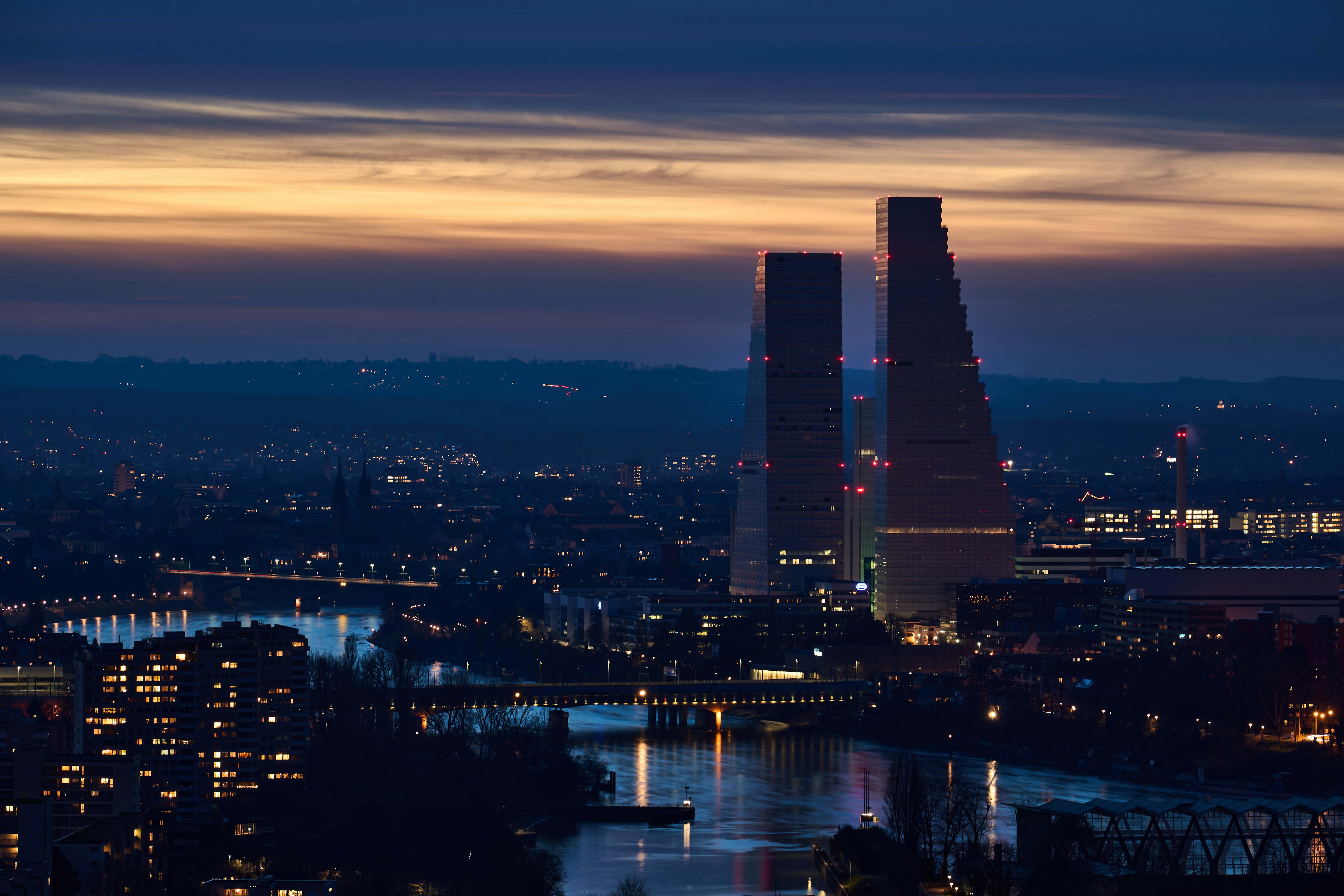 Blick auf eine Stadt bei Nacht von einem Hügel aus