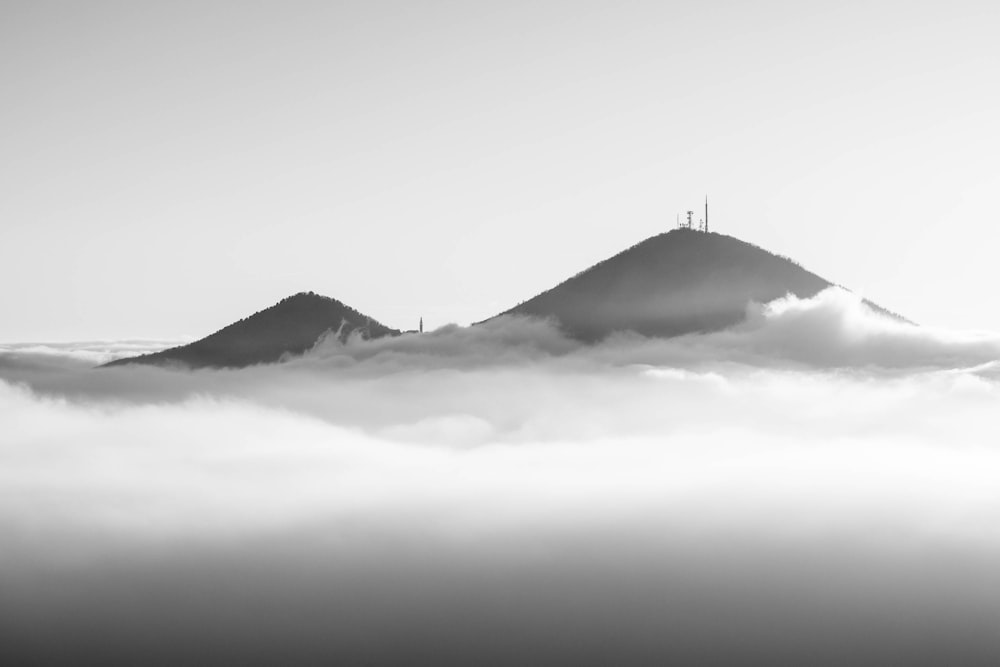 a black and white photo of a mountain in the clouds