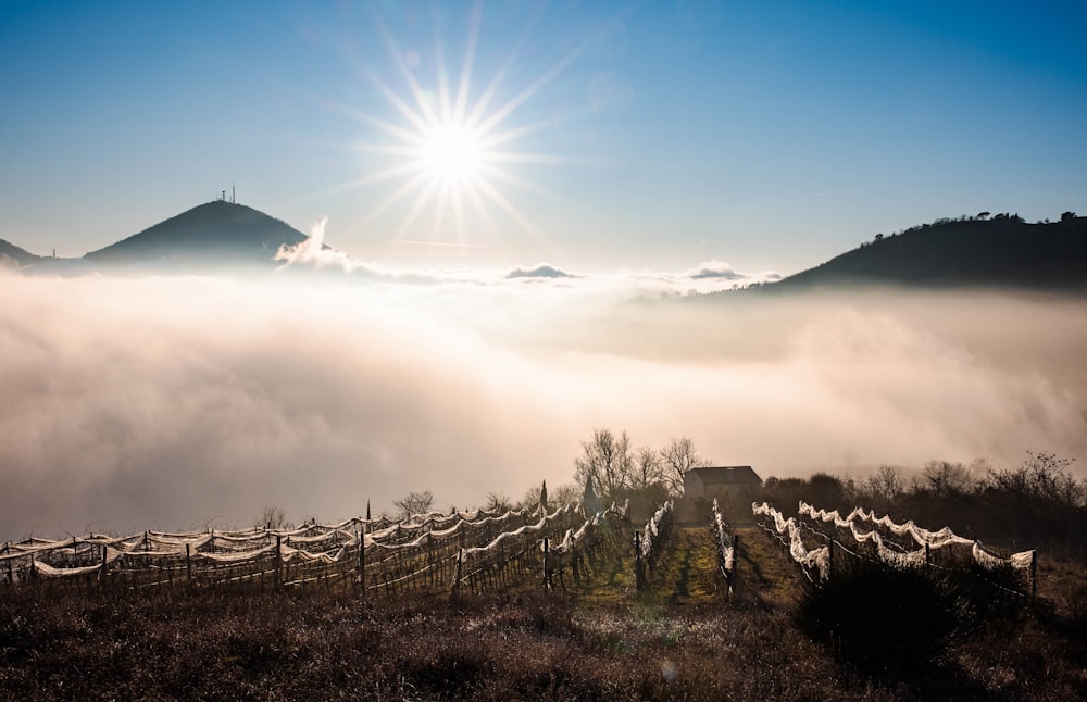 the sun is shining above the clouds in the mountains