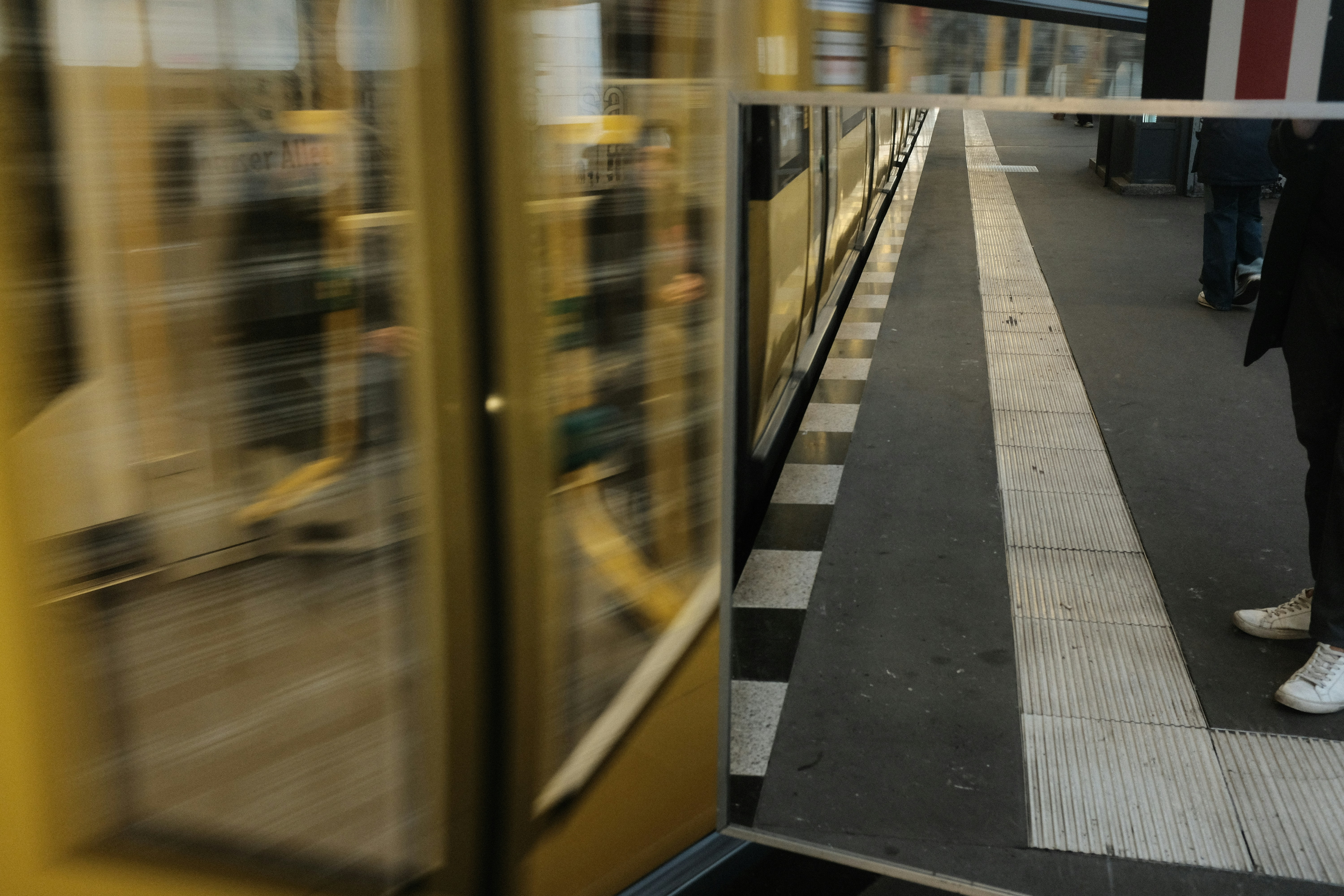 una persona parada en un andén junto a un tren