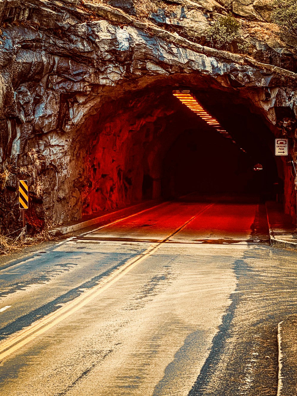 a road going into a tunnel with a red light at the end