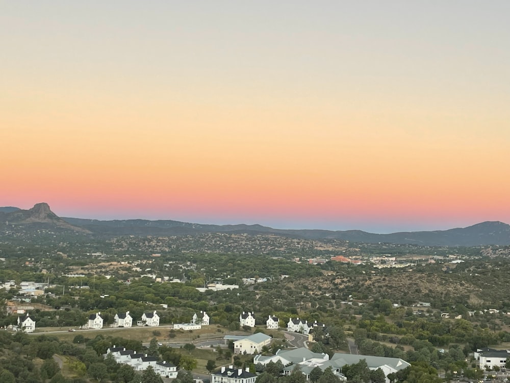 an aerial view of a town with mountains in the background