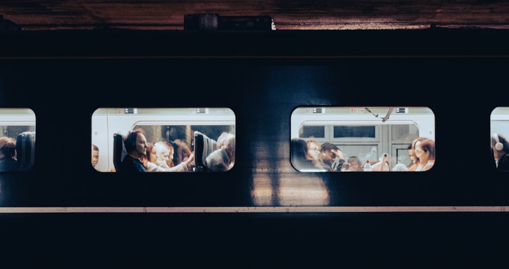 a group of people sitting on a train next to each other