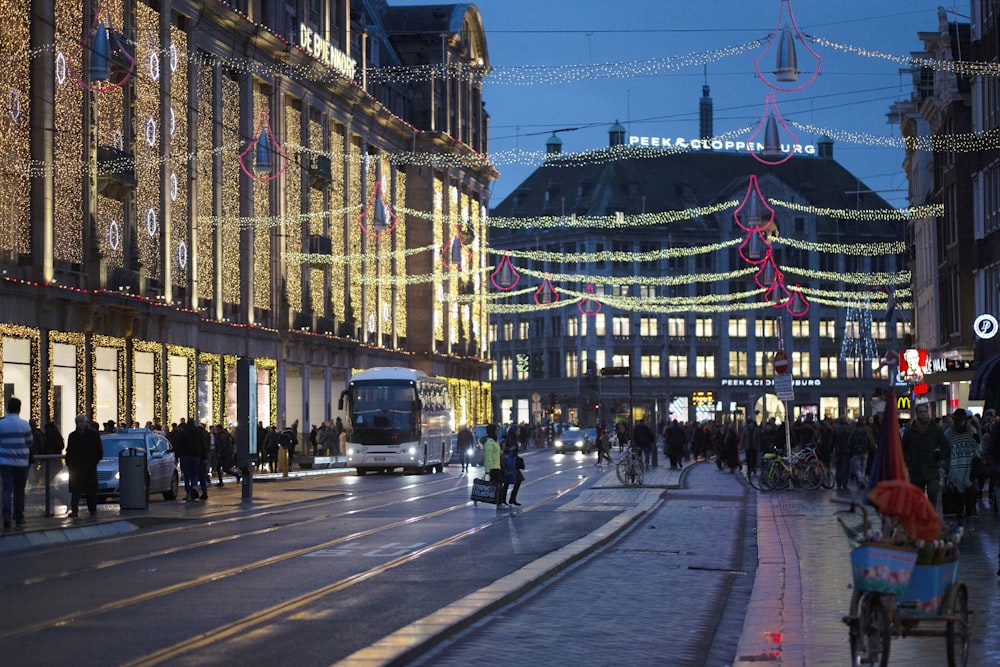 a busy city street at night with people walking and riding bikes