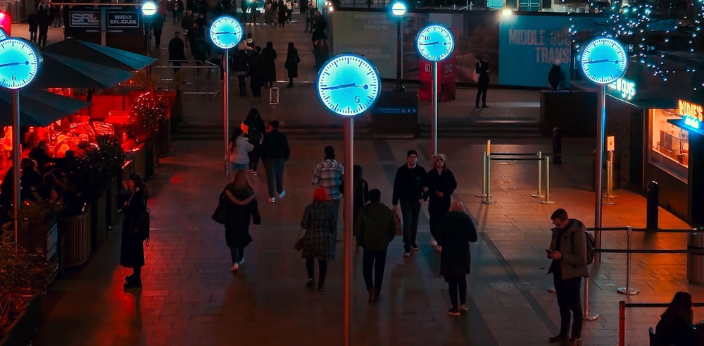 a group of people walking down a street at night