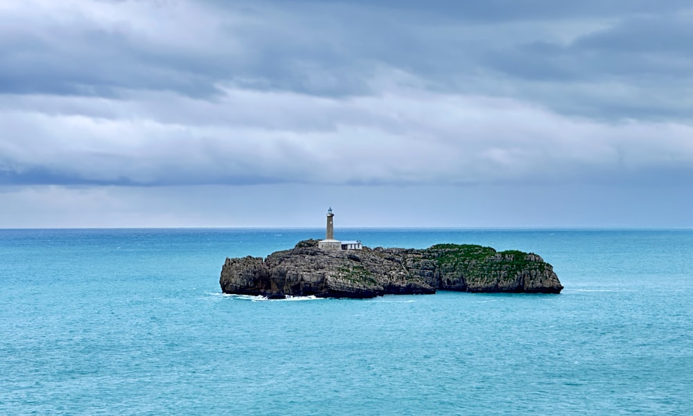 a lighthouse on an island in the middle of the ocean