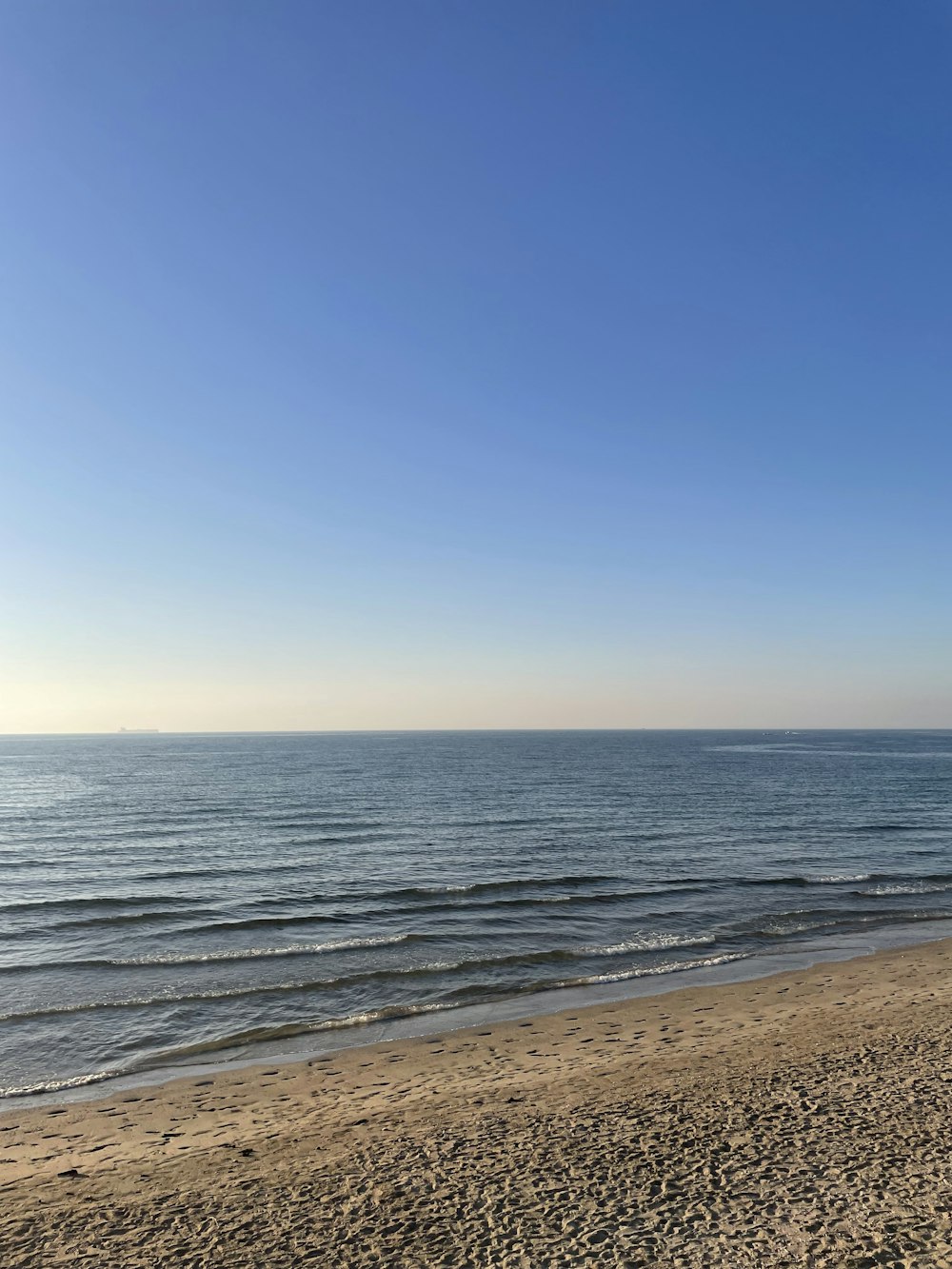 a person walking on a beach with a surfboard