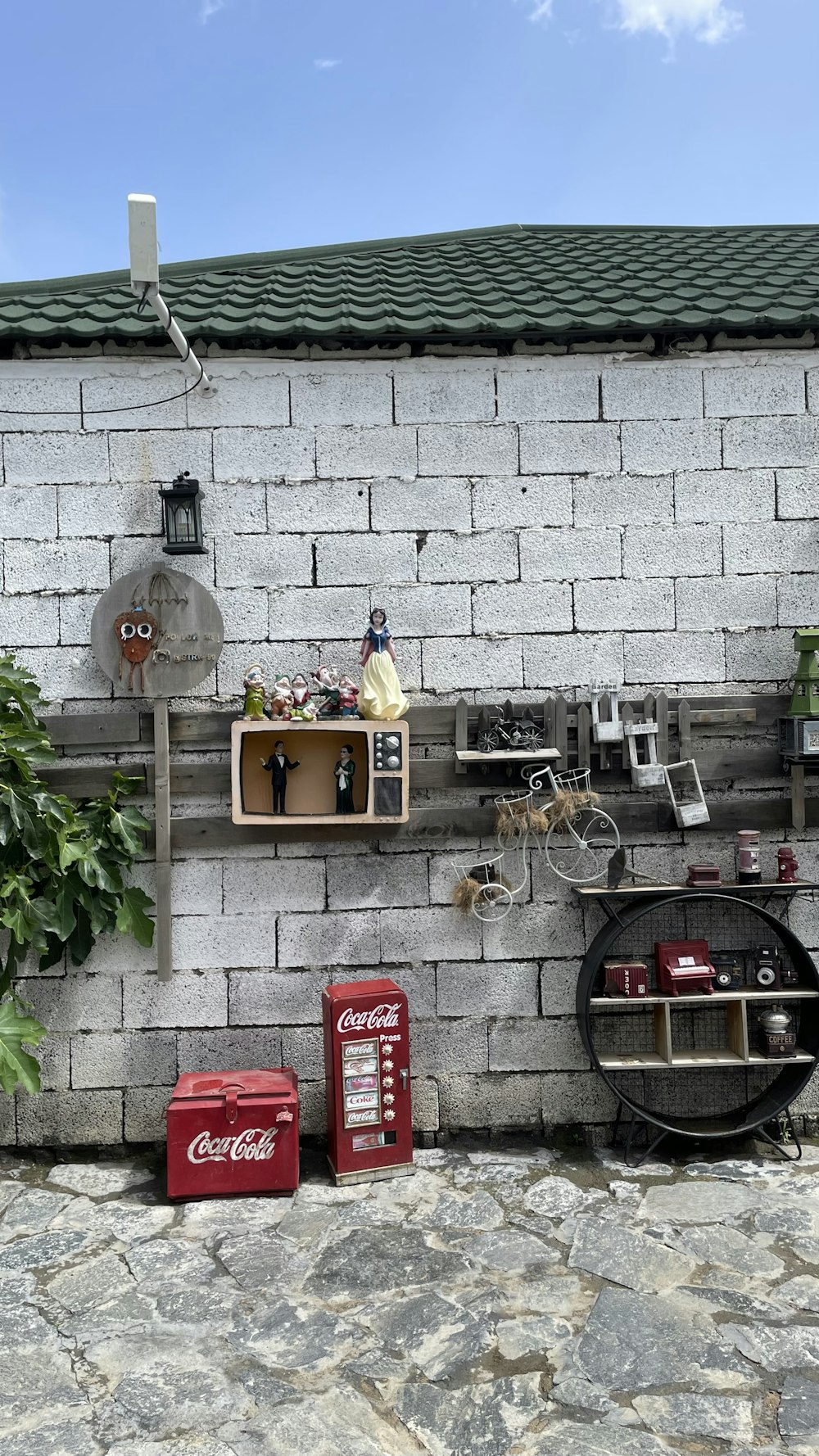 a white brick wall with a shelf of soda cans and other items