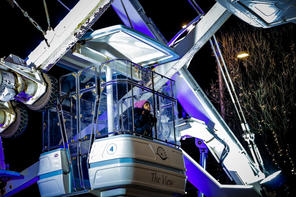 a man standing on top of a crane at night