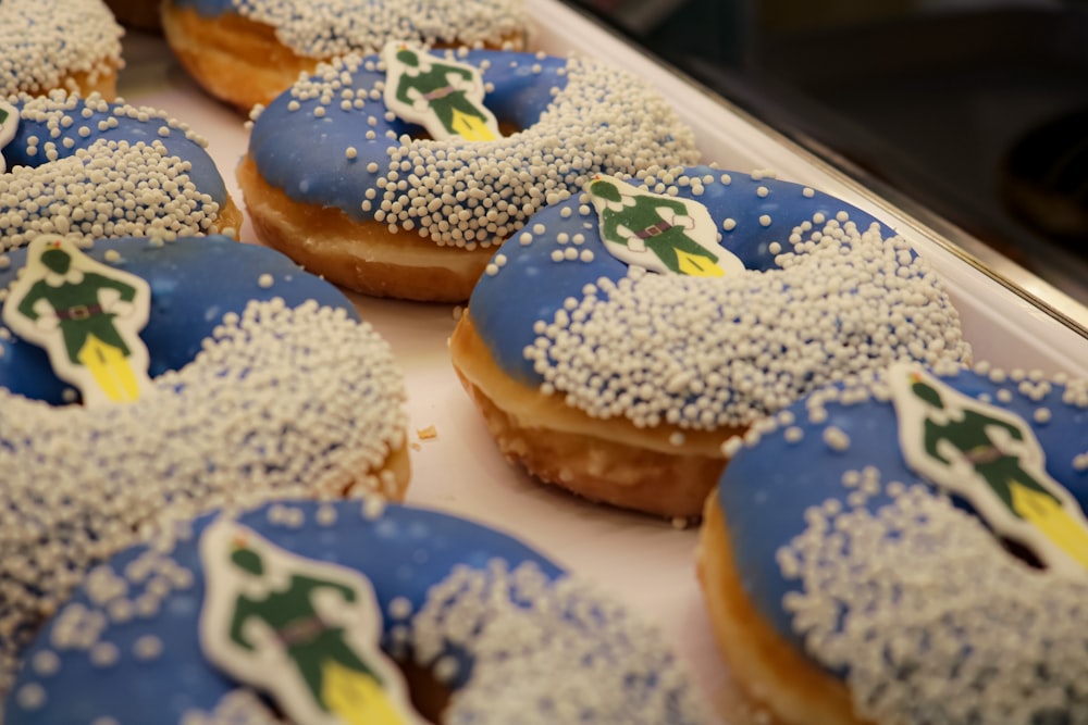 a close up of a tray of doughnuts with frosting