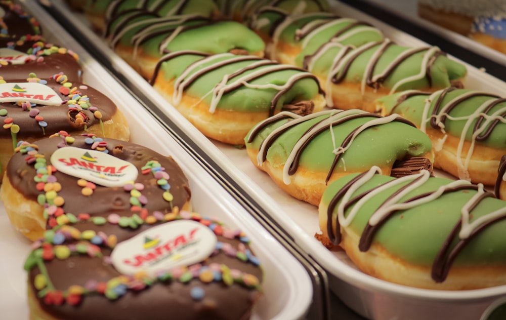 a display case filled with lots of donuts covered in green frosting