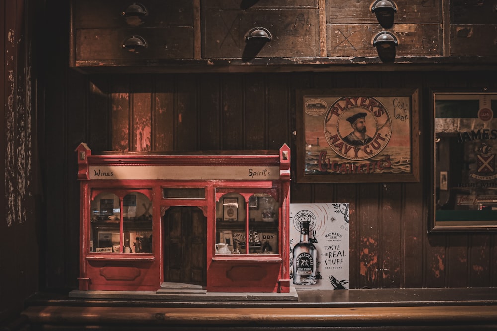 a red store front with a bottle of whiskey on the counter