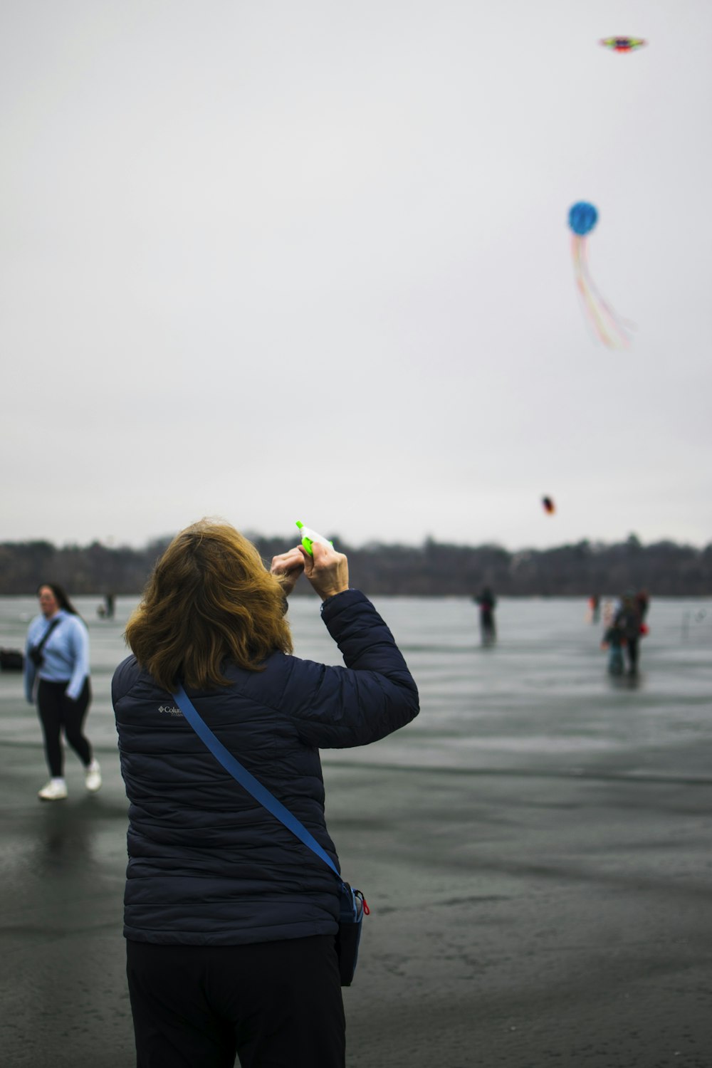 a woman is flying a kite on a cloudy day