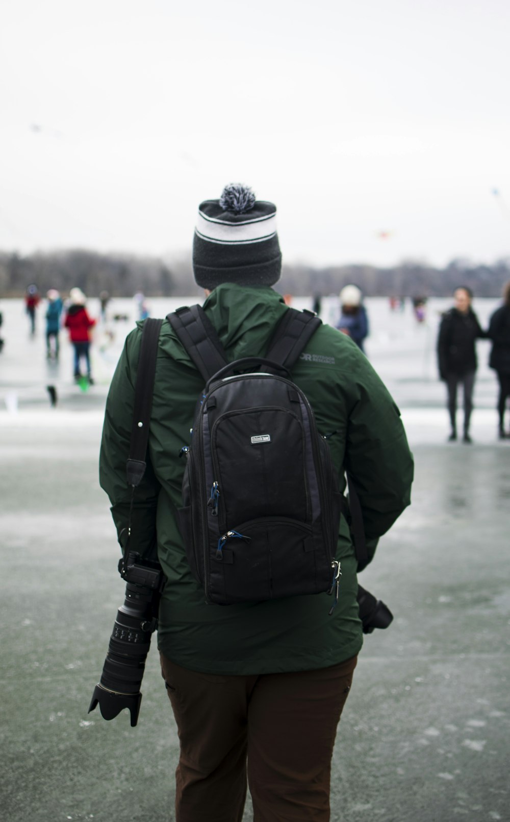 a person in a green jacket and a black backpack