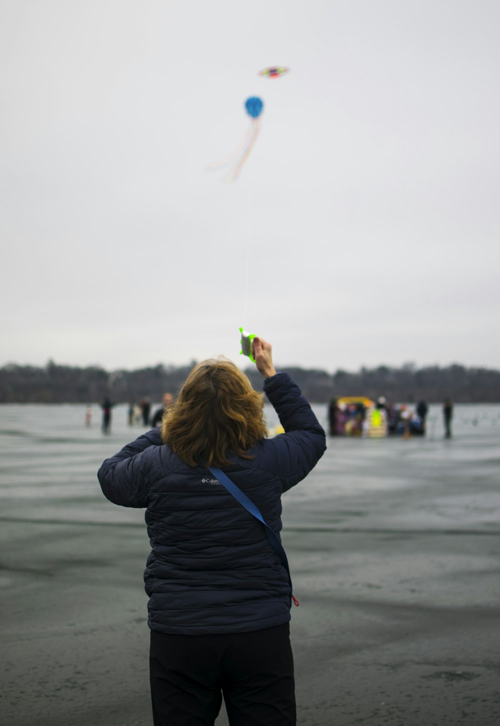 a woman is flying a kite on the beach