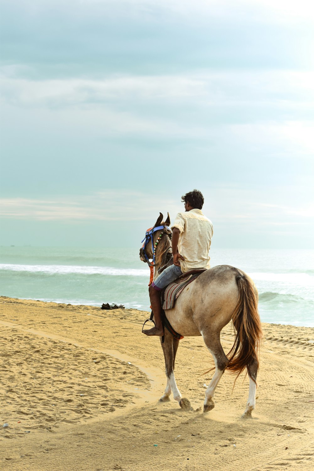a man riding a horse on the beach