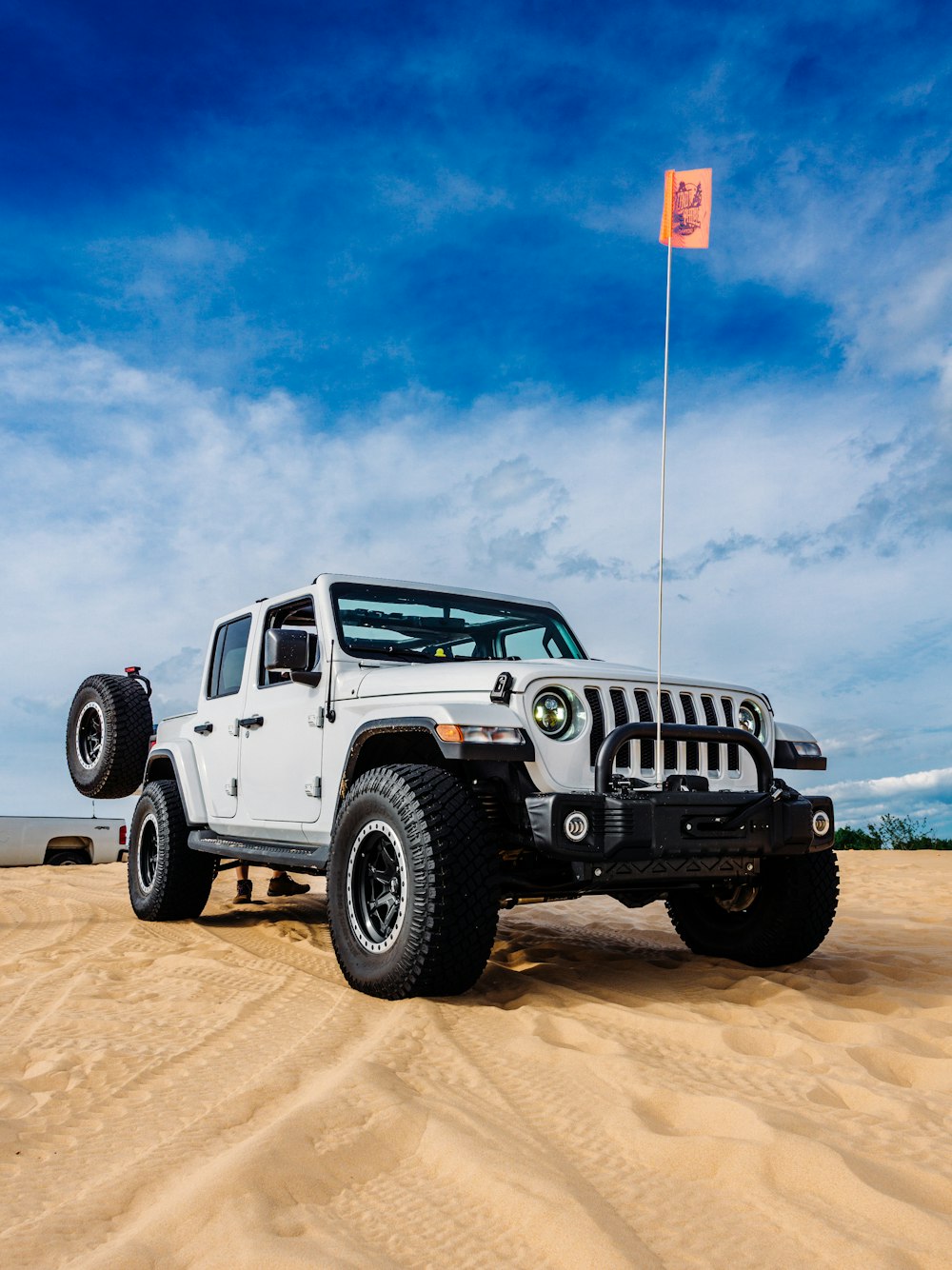 a white jeep with a flag on top of it
